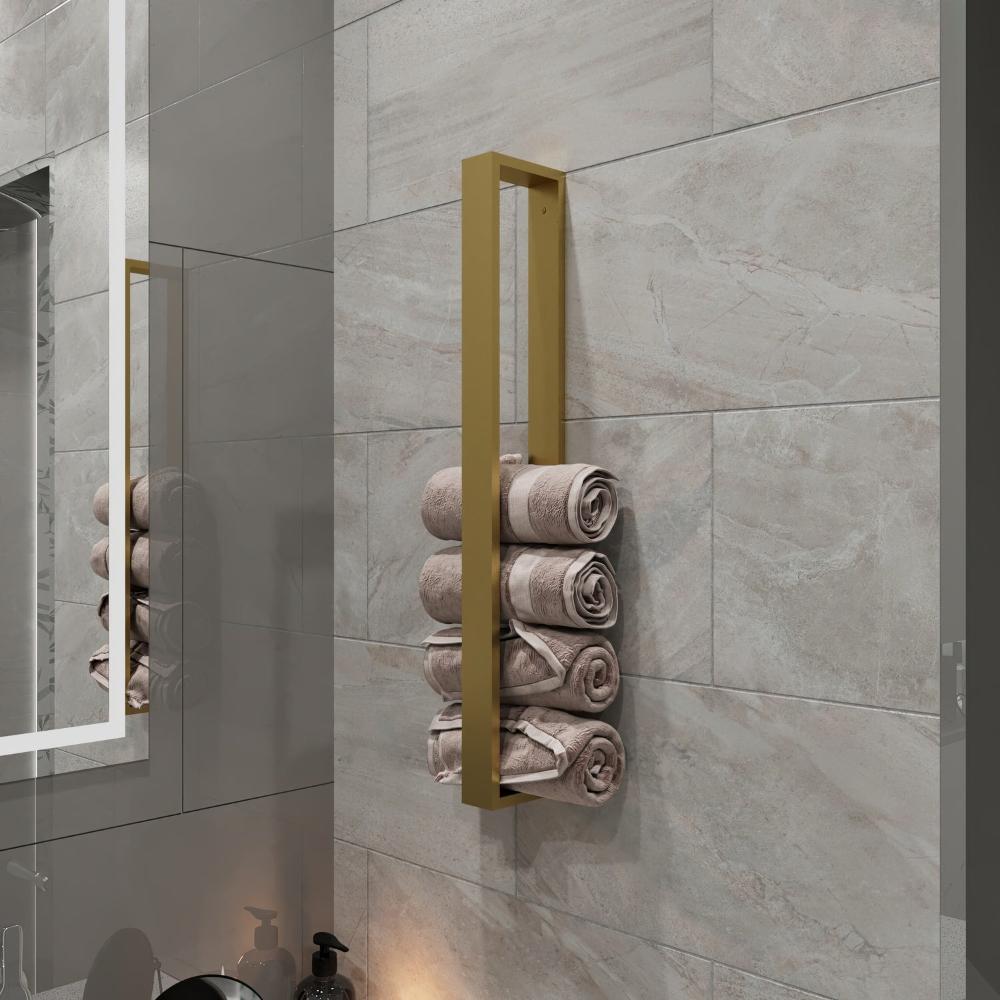 A gold, wall-mounted, minimalist vertical towel storage rack installed in a modern bathroom with light gray tiles. The rack holds multiple rolled towels in a neat, organized fashion, adding a touch of elegance and functionality to the bathroom decor. The design emphasizes simplicity and practicality, perfect for compact spaces.