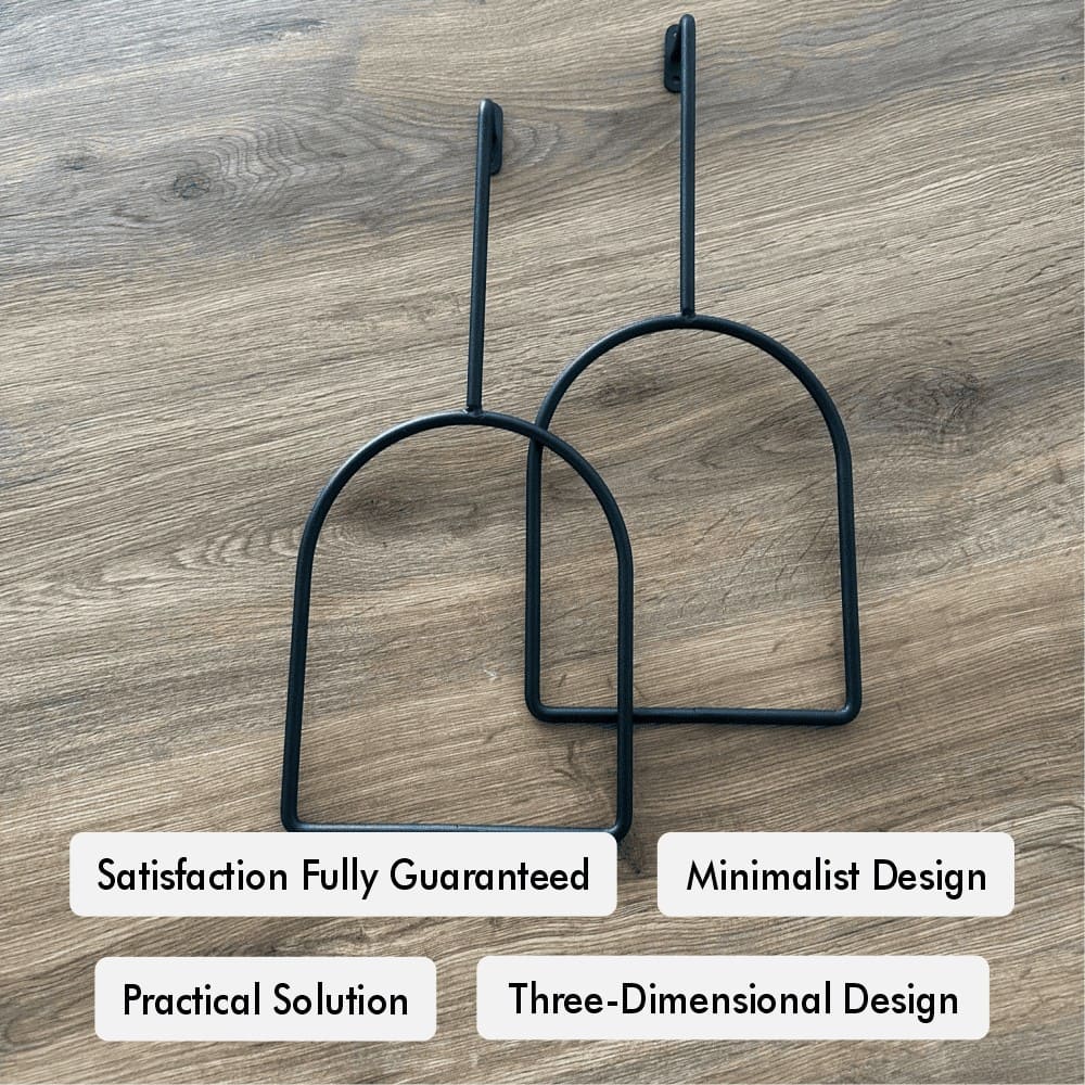 Pair of minimalist black wall hooks placed on a wooden surface, showcasing a three-dimensional design, with labels highlighting satisfaction guarantee, practical solutions, and modern minimalist appeal.