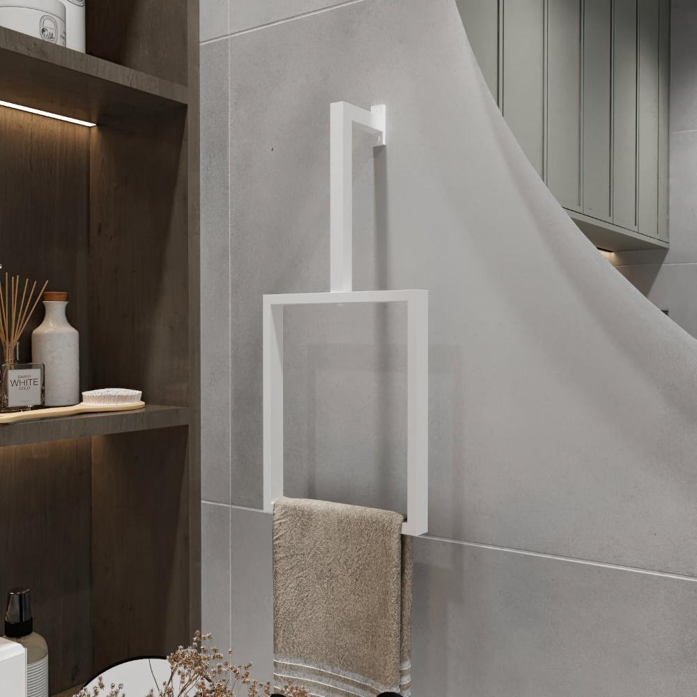 A minimalist white-finished vertical towel ring is mounted on a light gray wall. The modern rectangular design holds a beige towel, adding a clean and stylish touch to the bathroom decor. The sleek towel ring enhances the minimalist aesthetic of the space, perfectly complementing the surrounding neutral tones and simple design elements.