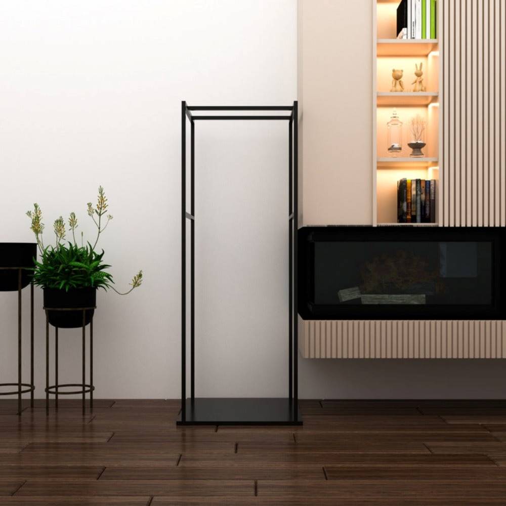 A black metal firewood rack with a minimalist and modern design, standing empty in a contemporary living room. The room includes wooden flooring, decorative plants, a sleek fireplace, and illuminated shelving with decorative items.