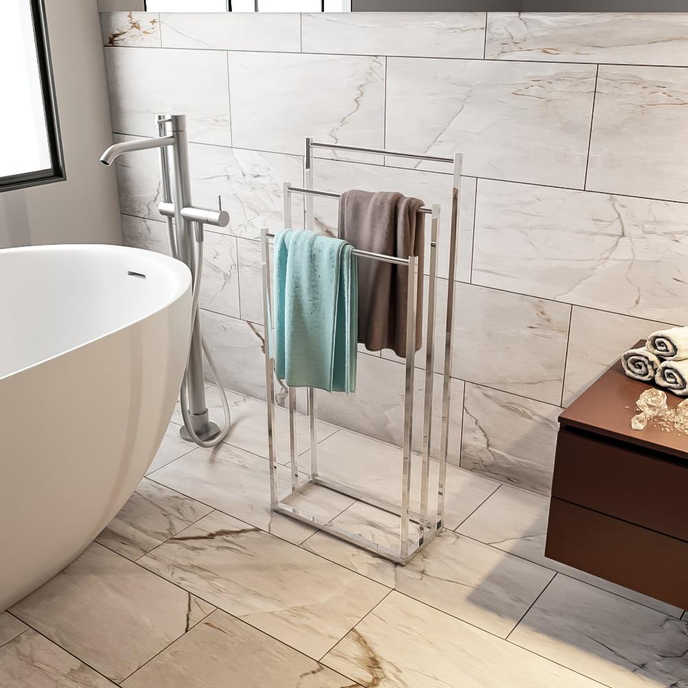 Contemporary bathroom setup featuring a sleek silver floor-standing towel rack holding neatly arranged towels, complementing the luxurious marble tile walls and a modern freestanding bathtub.