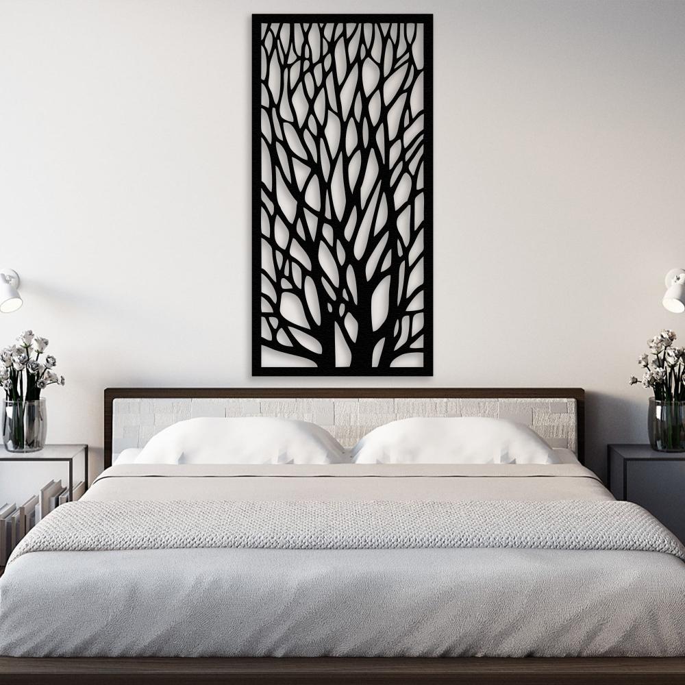 Black metal tree wall art featuring intricate branching patterns mounted above a modern bed with a white headboard and neutral bedding. The bedside tables are decorated with vases of white flowers and modern lamps, creating a serene and elegant bedroom atmosphere.