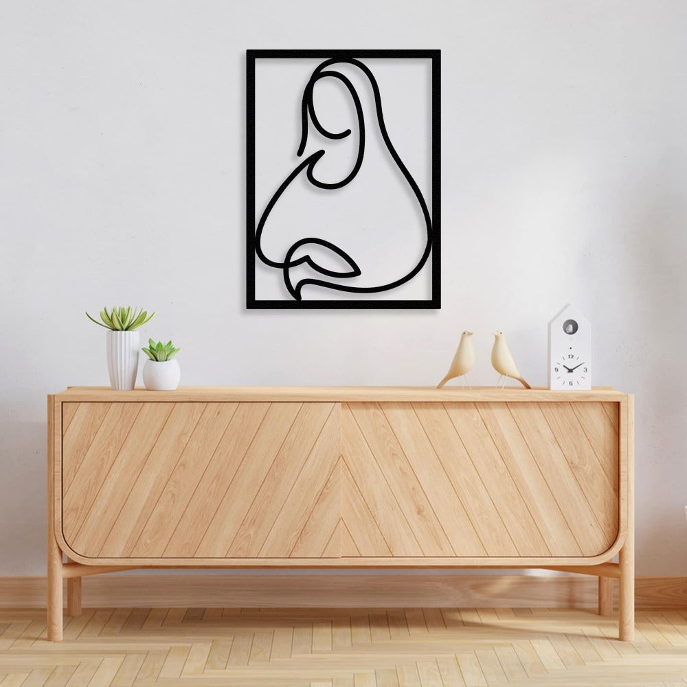 A sleek metal wall art piece of the Mona Lisa in black, placed on a light wall above a stylish wooden console with decorative accents.