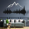 Stunning metal wall art featuring a white mountain silhouette above a black forest design, elegantly mounted on a dark blue wall in a modern living room with a green sofa, white cushions, and a wooden coffee table.