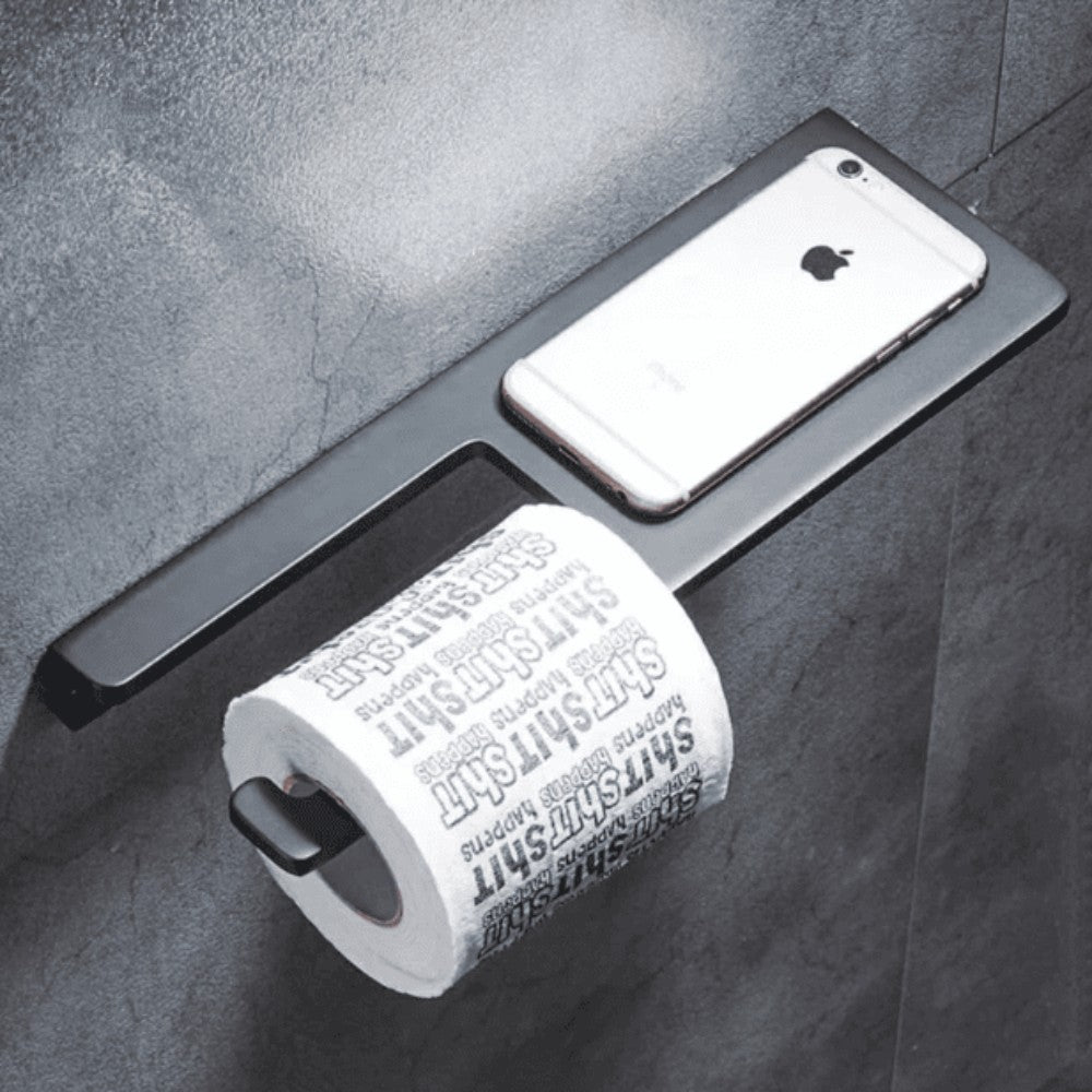 Modern multifunctional bathroom shelf with a sleek black design, featuring a built-in toilet paper holder and a flat surface for holding small items like a smartphone, mounted on a dark gray tiled wall