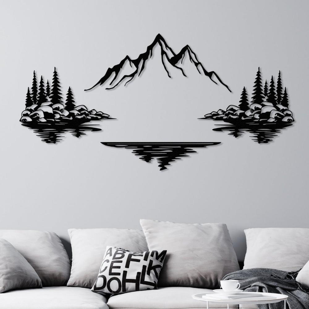 Nature-themed metal wall art featuring a mountain in the center with trees and rocks on both sides, their reflections in the lake below. The black metal design is mounted on a gray wall above a modern sofa.