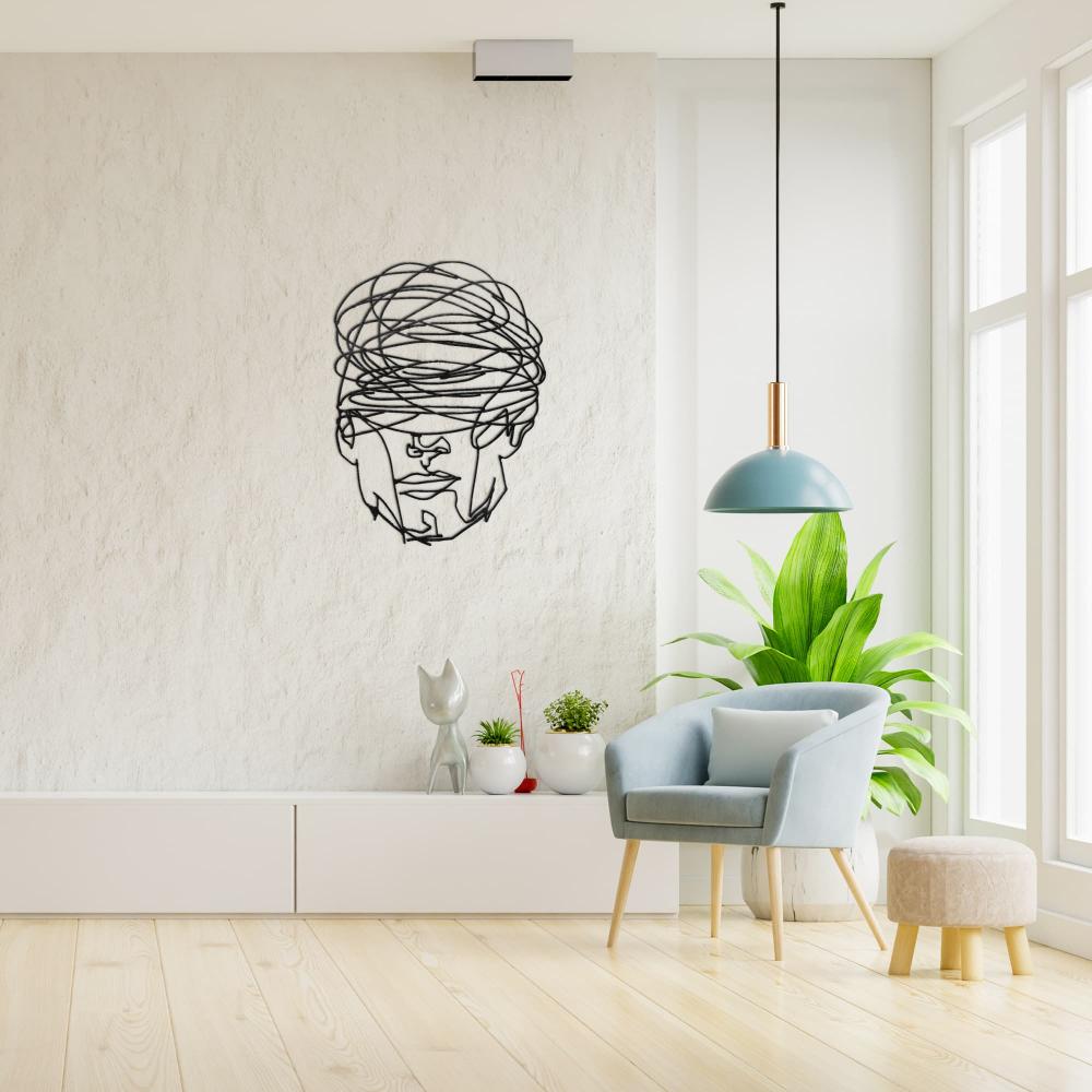 Bright and modern living room featuring "Overthinking Man" black metal wall art on a textured white wall, styled with a light blue armchair, a beige ottoman, a green potted plant, and a minimalist pendant light.