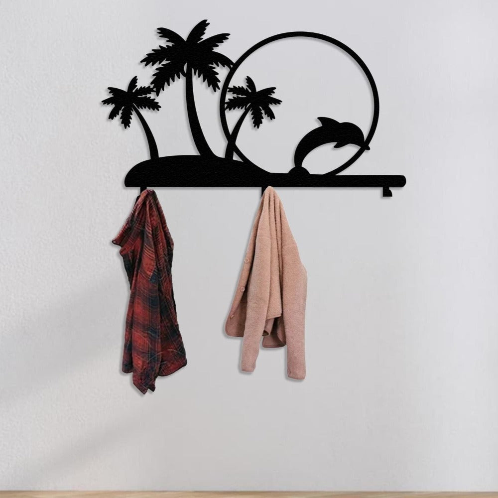 A black metal wall-mounted rack featuring palm trees and a dolphin jumping through a circle. The tropical-themed rack holds a red plaid shirt and a beige coat, offering a decorative and functional storage solution.