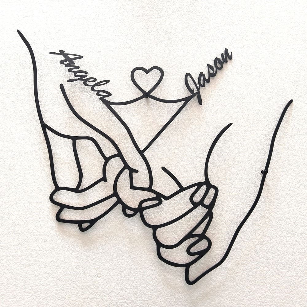 Personalized metal wall art featuring intertwined hands with the names "Angela" and "Jason," connected by a heart design, symbolizing love and unity, ideal for gifting or home decor.