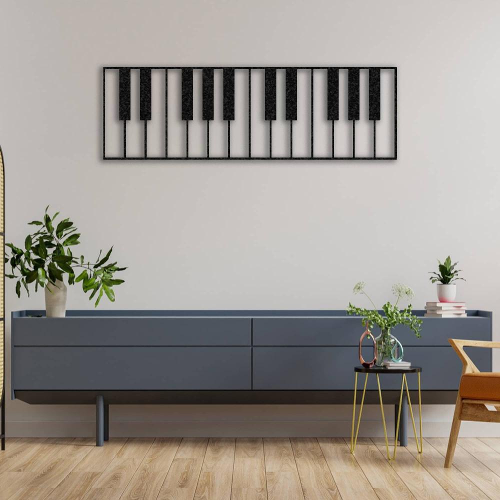 Piano keys-themed metal wall art in a sleek black design, mounted on a neutral-colored wall above a modern blue console table. The room is decorated with plants, books, and minimalist furniture, creating a stylish and artistic ambiance.