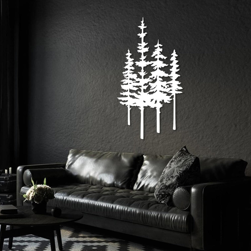 White metal wall art featuring tall pine trees mounted on a dark textured wall, positioned above a black leather sofa with matching throw pillows in a modern living room.