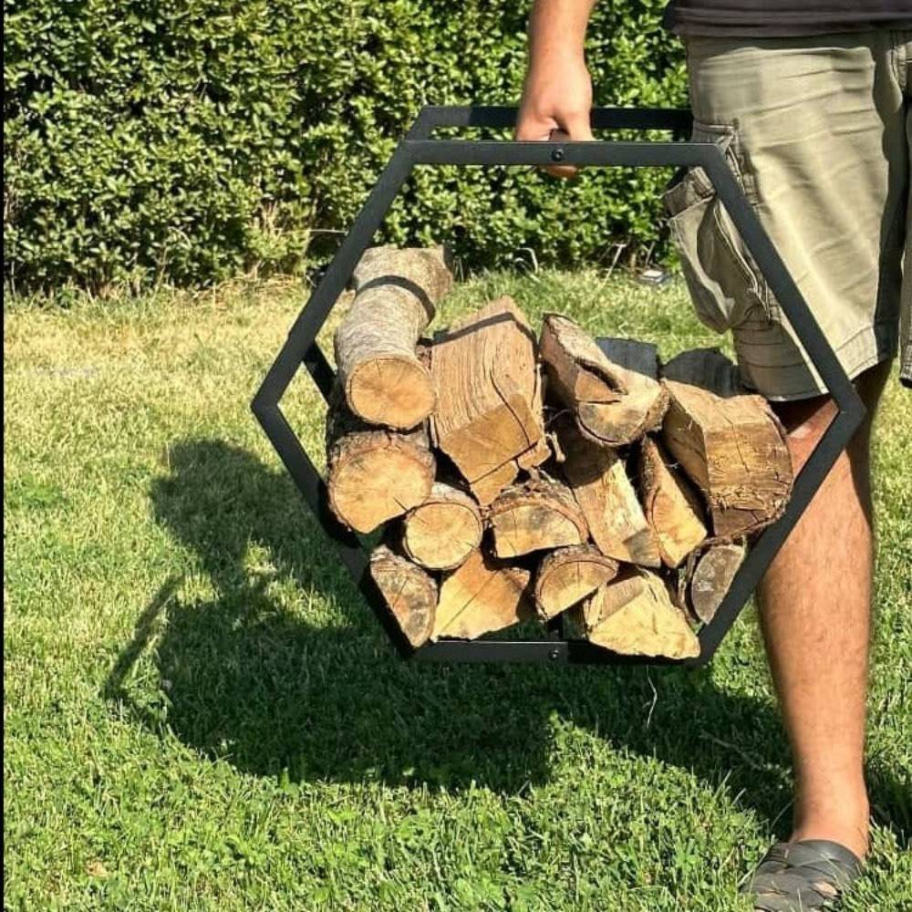 A portable hexagonal-shaped firewood rack being carried by a person, filled with chopped firewood logs, highlighting its lightweight and functional design.