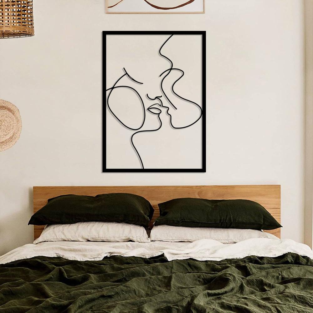 A warm and inviting bedroom with colorful throw pillows, a textured headboard, and a "Relationship Goals" metal wall art showing an abstract couple design in a modern minimalist style.