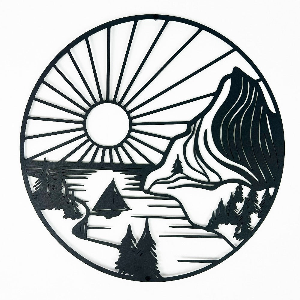 Round metal wall art featuring a detailed mountain scene with a radiant sun, trees, and a sailboat on a tranquil river, crafted in intricate black metal.