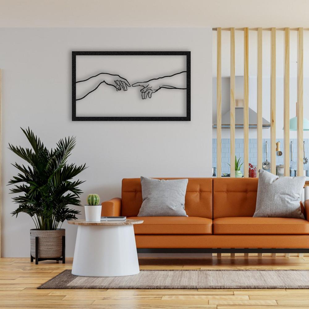 Black metal "Creation of Adam" wall art displayed above a modern orange sofa with gray cushions, accompanied by a white round coffee table, a green potted plant, and a neutral rug, set against a minimalist interior with a wooden divider leading to the kitchen.