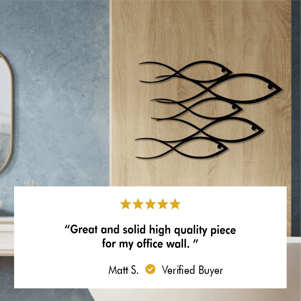 "School of Fish" metal wall art mounted on a light wood panel in a modern office space. Includes a 5-star review: "Great and solid high quality piece for my office wall." - Matt S., Verified Buyer.