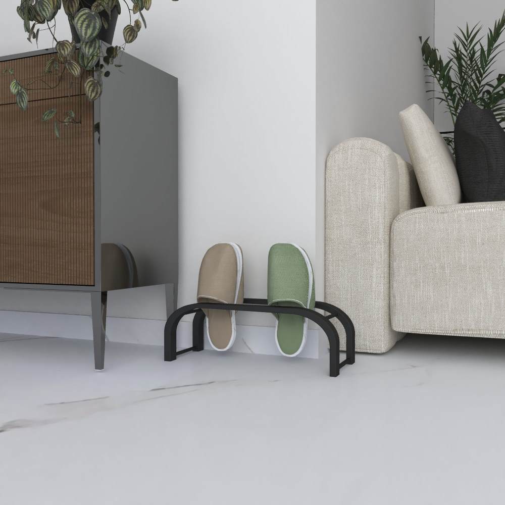 A black slipper rack holding a pair of beige and green slippers, placed in a cozy corner next to a light beige sofa and a modern cabinet with plants adding a decorative touch to the space.