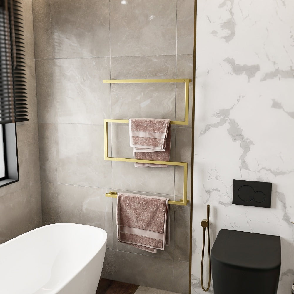 Modern bathroom featuring a gold, space-saving, rust-resistant metal towel holder. The holder is mounted on a wall with light grey tiles and holds neatly folded pink towels. The setup adds a luxurious and functional touch to the elegant bathroom space.