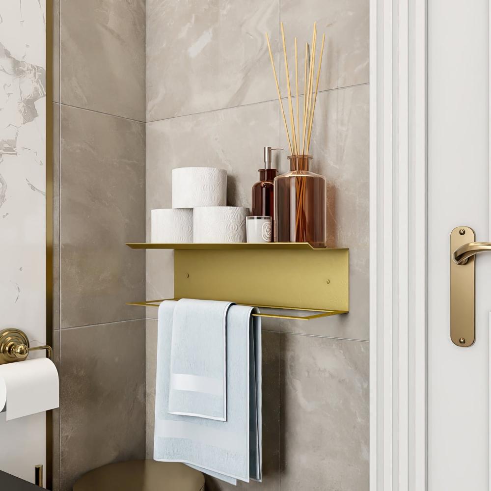 A gold towel holder with a shelf, styled with toiletries and reed diffusers, creating an elegant touch in a bathroom setting.