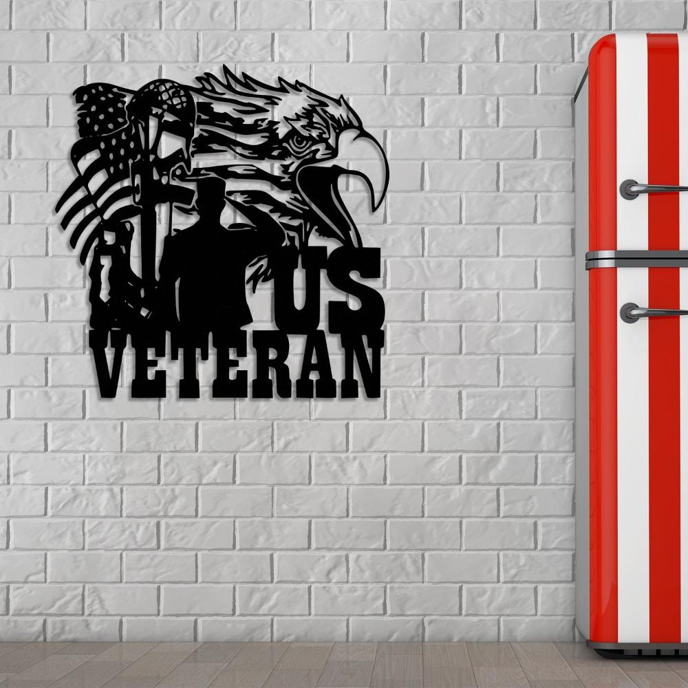 Black US veteran metal wall art featuring an eagle, American flag, and soldier silhouette, mounted on a white brick wall near a retro-style red and white striped refrigerator.