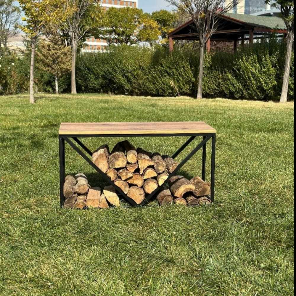 A black metal wood rack with a wooden top and a V-shaped design for storing firewood, set outdoors on a grassy lawn