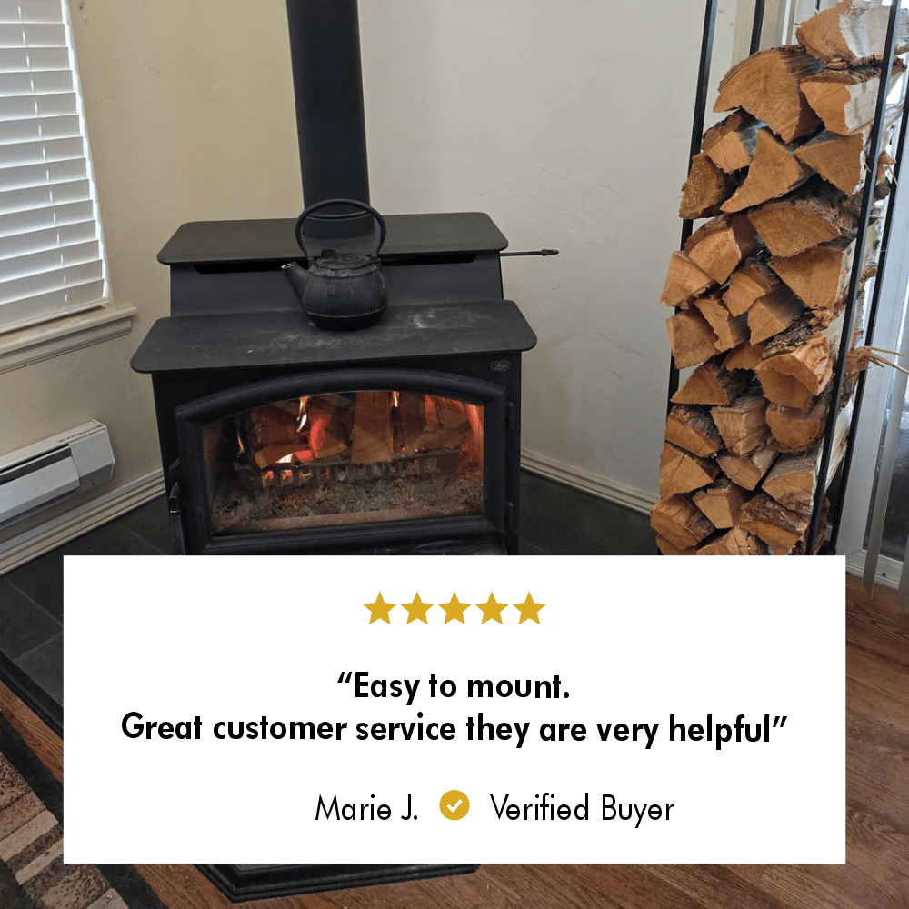 Vertical firewood storage rack next to a wood-burning stove, with a five-star review from verified buyer Marie J. stating 'Easy to mount. Great customer service they are very helpful.'