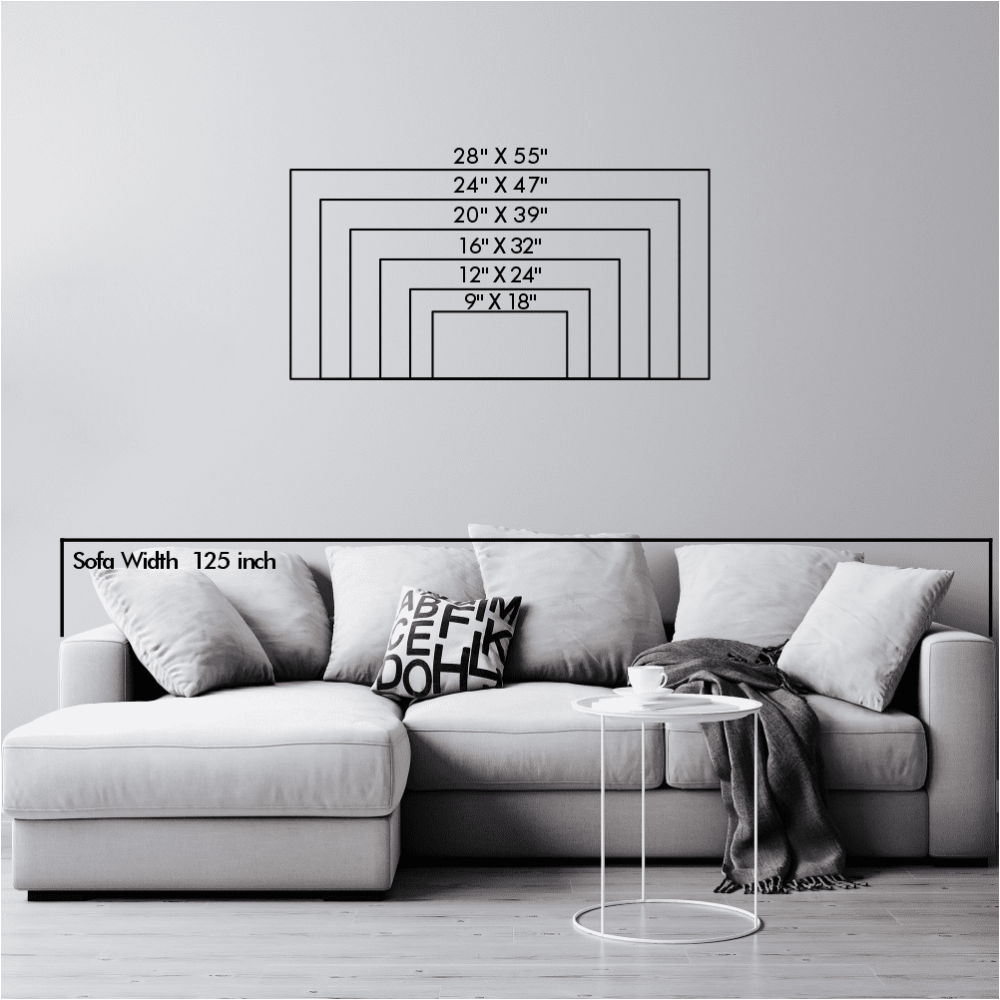 Size chart illustration displaying various landscape dimensions of wall art ranging from 9" x 18" to 28" x 55", positioned above a modern white sofa with a width of 125 inches. The sofa features soft cushions, one with abstract typography, and a cozy throw blanket. A small round side table with a cup completes the setup.