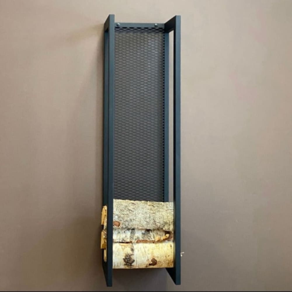 A tall, wall-mounted firewood holder with a sleek black frame and mesh back, partially filled with logs, displayed on a brown wall.