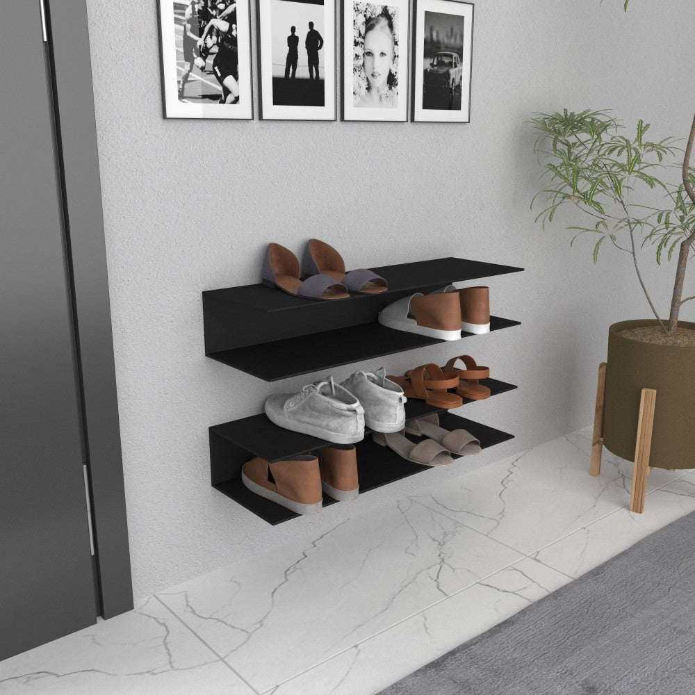 A modern wall-mounted horizontal shoe rack with three black shelves, showcasing various shoes neatly arranged in an entryway with framed black-and-white photos on the wall and a green plant in a pot nearby.