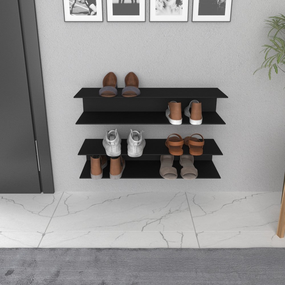 A front-facing view of a black wall-mounted horizontal shoe rack with three shelves holding different types of shoes, positioned in a minimalistic hallway with marble flooring.