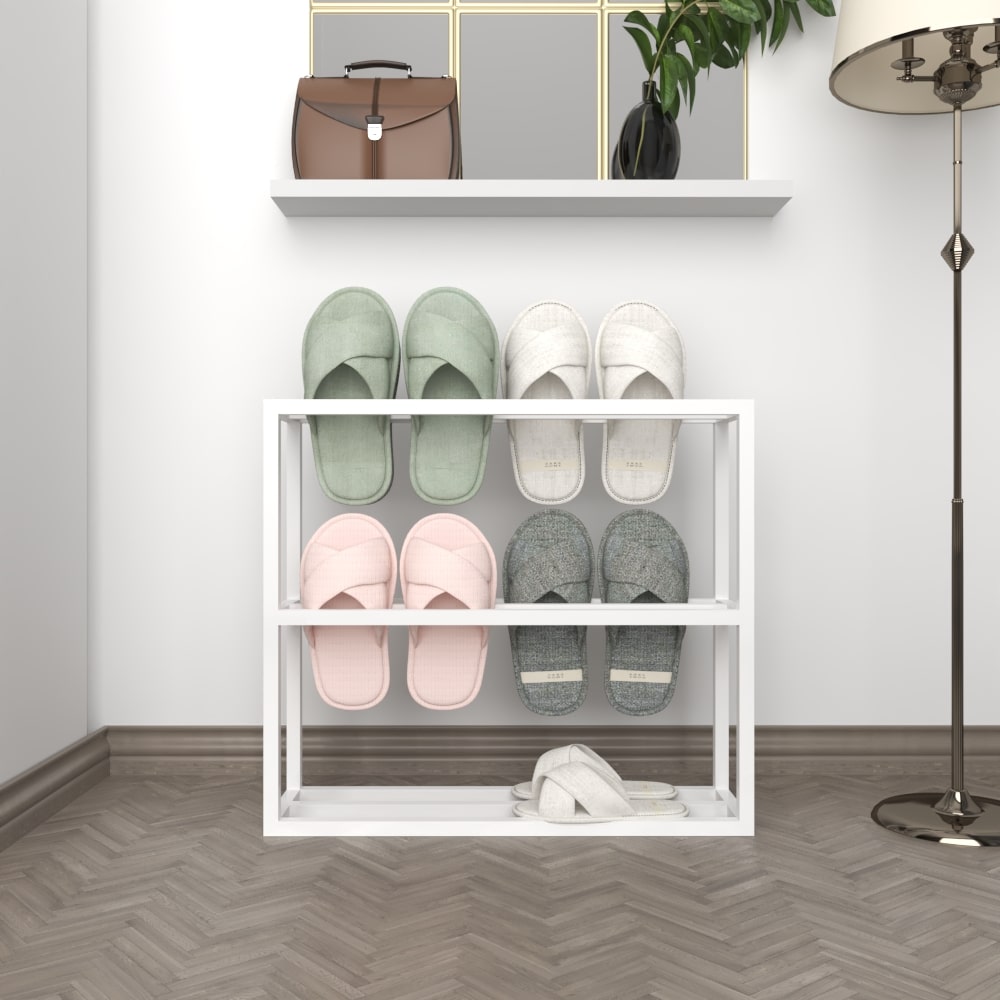 A white metal slipper rack with two pairs of white and green slippers, set against a neutral wall with a wooden floor for a clean, modern look