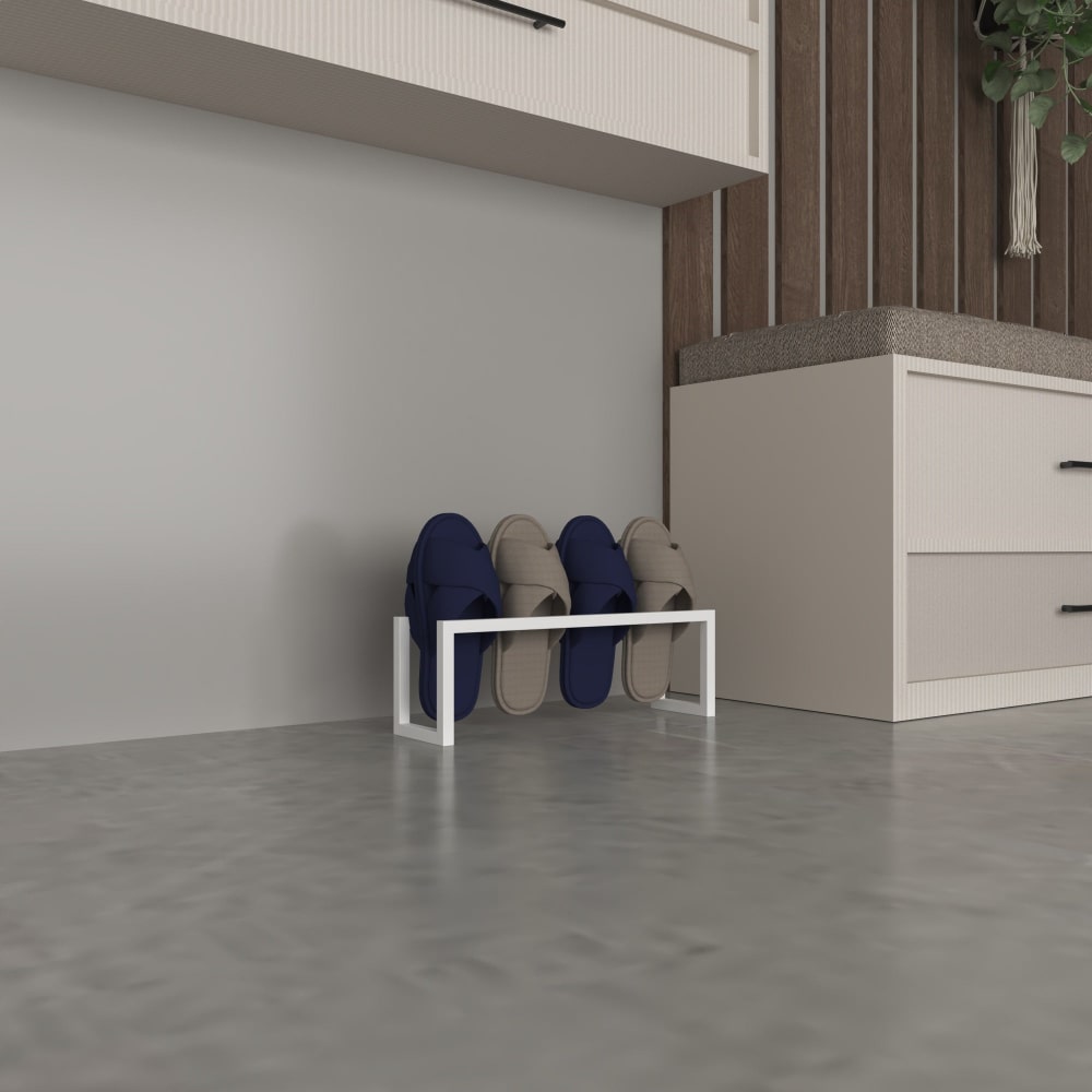 A white metal slipper rack holding blue and gray slippers, positioned against a plain wall in a minimalist space