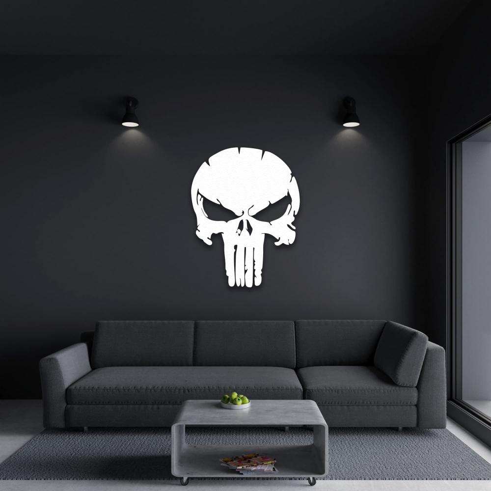 Modern living room with dark walls and a striking white Punisher skull metal wall art above a sleek gray sofa, illuminated by minimalist wall lights.