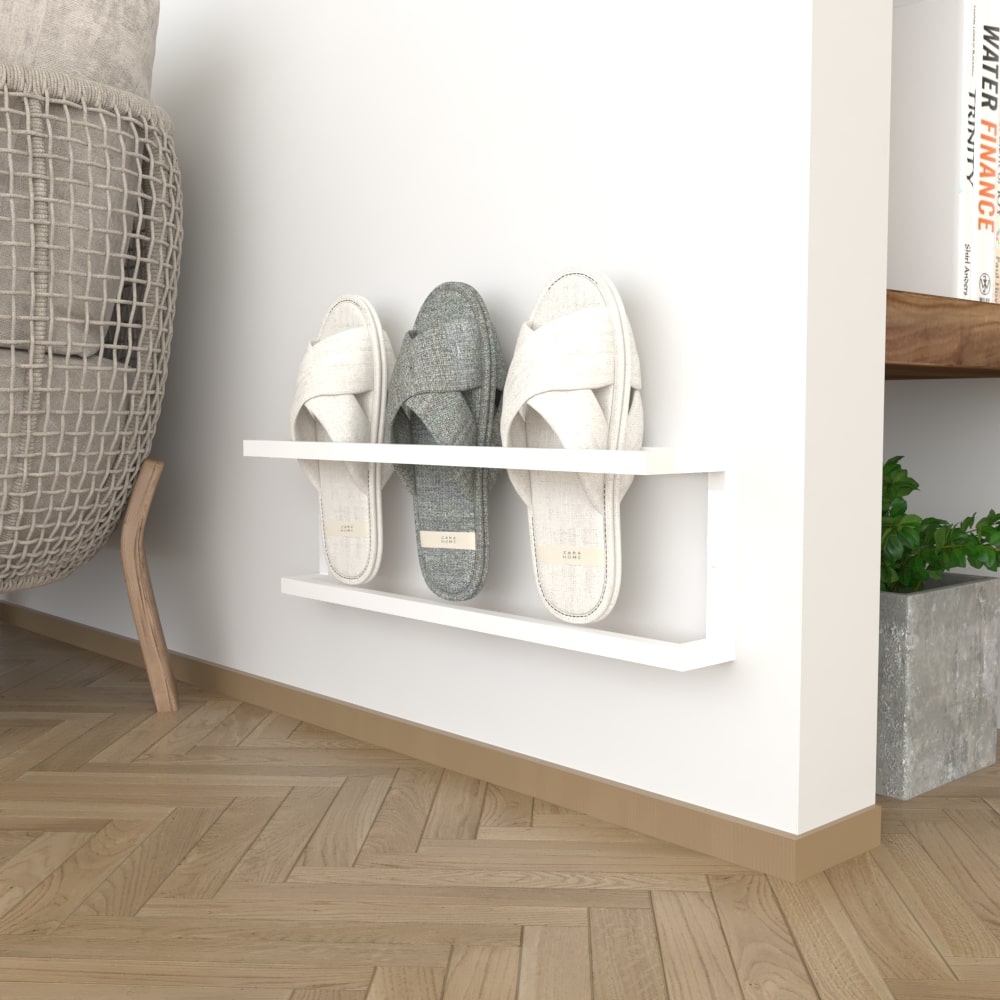 A white wall-mounted slipper rack featuring three pairs of slippers, blending into a bright, modern room with light wood flooring and minimal decor.