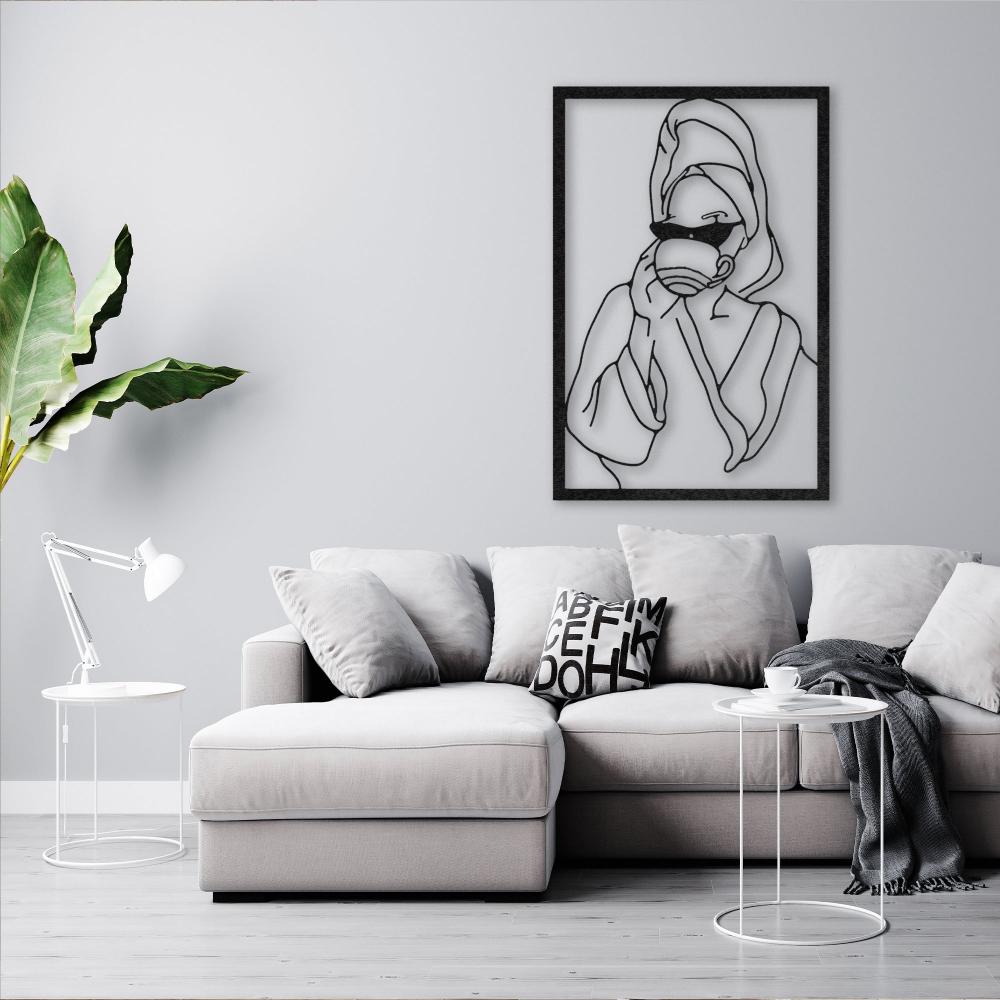 Modern living room with a cozy gray sofa and a chic metal wall art featuring a woman in sunglasses and a towel, holding a cup, mounted on a light gray wall.